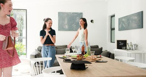 Women celebrating graduation in bright dining room