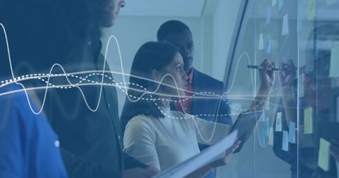 Diverse team collaborating on glass board with sticky notes and data waveform overlay