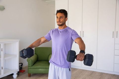 Man Doing Strength Training with Dumbbells in Home Living Room