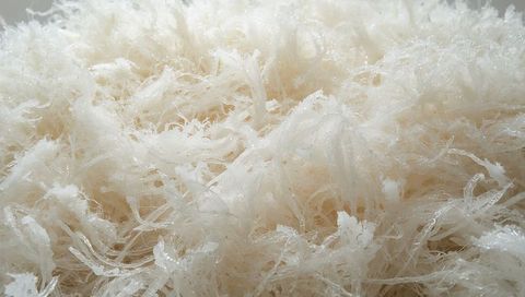 Macro texture showing translucent filaments with glistening droplets, fluffy fibrous mass