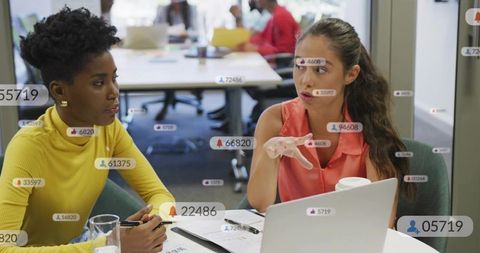 Two professionals discussing social media analytics during collaborative office planning