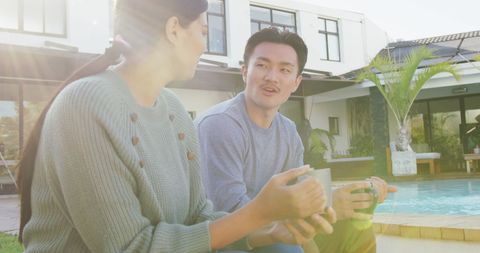 Couple Enjoying Coffee Together by Poolside