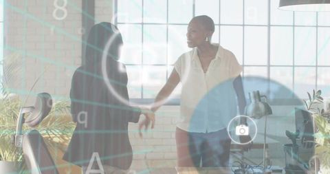 Two professionals shaking hands in modern loft office with digital network overlay