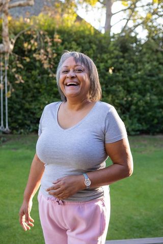 Senior african american woman relaxing in sunny backyard
