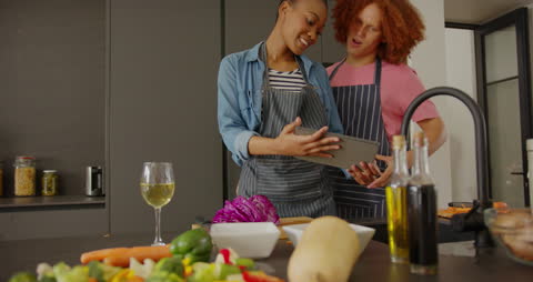 Couple Preparing Meal Using Tablet for Recipe in Modern Kitchen