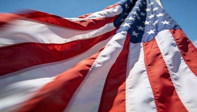 Billowing american flag close-up with stars and stripes against blue sky