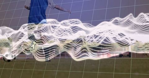 Athlete in Blue Vest Kicking Soccer Ball with Futuristic Analytics