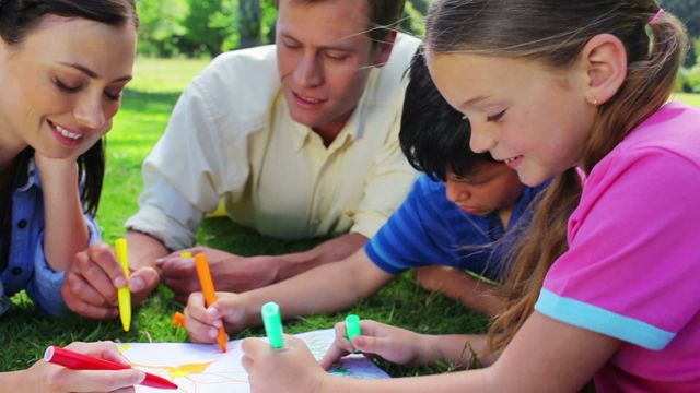 Parents and children enjoying art activities on grassy ground while smiling. Ideal for depicting family bonding, outdoor activities, summer fun, creativity in nature, and leisurely weekend activities.