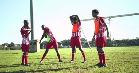Young athletes preparing on soccer field in vibrant striped kits