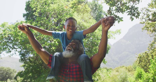 Happy grandfather giving grandson piggyback ride in nature - Download Free Stock Images Pikwizard.com