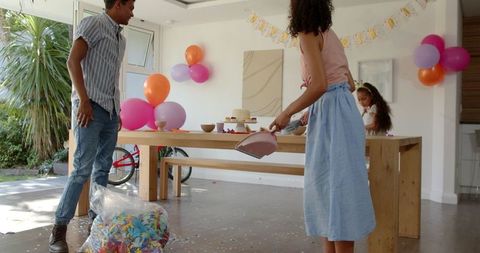 Couple Cleaning Confetti After Party in Modern Home