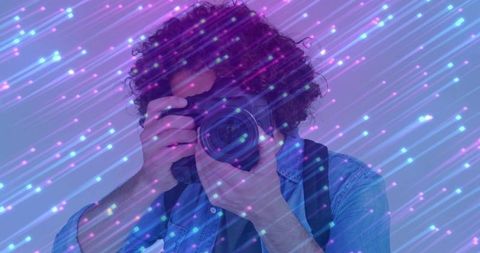 Photographer with dslr in vibrant artistic light overlay