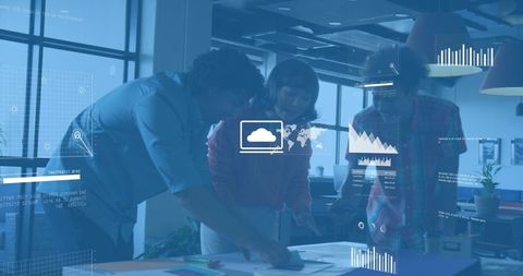 Diverse team collaborating around table with cloud analytics, charts and map overlays