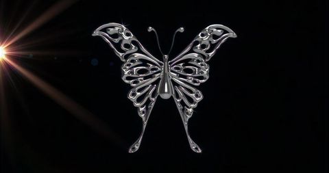 Gleaming silver butterfly sculpture with spotlight