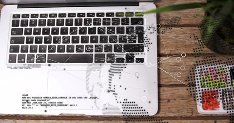 Minimalist laptop workspace showing code overlay and data network graphics on wood desk