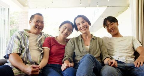 Happy Family Relaxing Together on Sofa Under String Lights