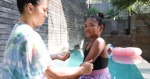 Mother and Daughter Bonding at Poolside with Donut Float and Beach Ball