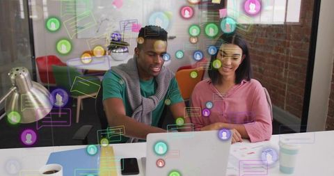 Collaborating team reviewing laptop with AR chat icons, planning digital workflow