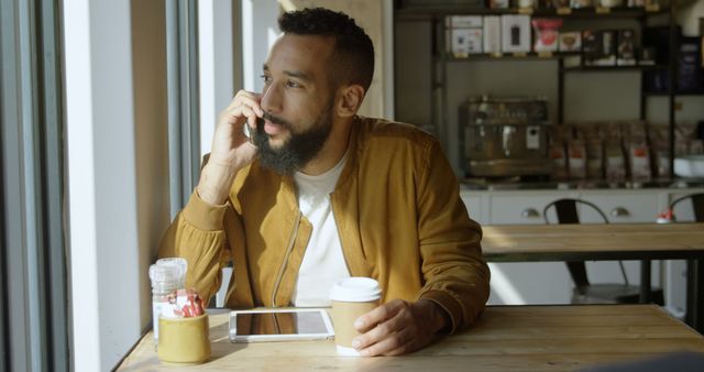 Man with Beard Drinking Coffee and Using Smartphone in Cafe - Download Free Stock Images Pikwizard.com