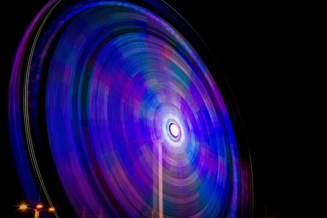 This highly artistic long exposure captures the vibrant and colorful light patterns of an illuminated ferris wheel at night. Perfect for use in creative projects, tech backgrounds, and artistic designs. Ideal for highlighting themes related to nightlife, amusement parks, celebrations, and colorful abstract art.