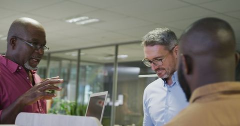 Diverse Colleagues Discuss in Modern Office Setting