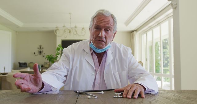 Senior Male Doctor Sitting at Table and Giving Advice in Office - Download Free Stock Images Pikwizard.com