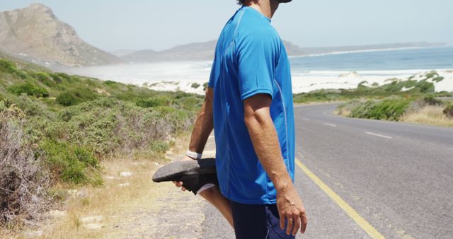 Man Stretching Leg Before Running on Coastal Road - Download Free Stock Images Pikwizard.com