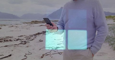 Man on Beach Using Smartphone With Digital Interface Overlay