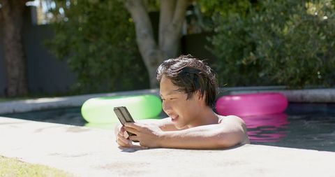 Relaxed Teen Enjoying Smartphone in Poolside Summer Vibes