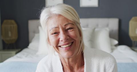 Smiling Senior Woman Relaxing at Home in Cozy Bedroom