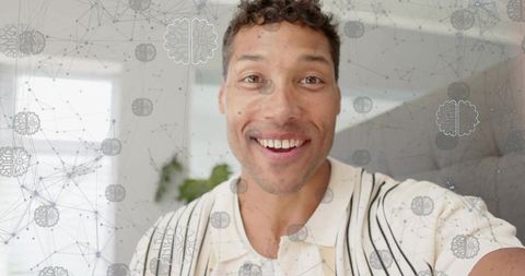 Smiling mid-adult man facing camera wearing striped shirt with neural network brain overlay
