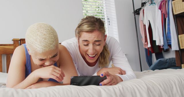 Diverse Friends Relaxing and Laughing Together on Bed with Smartphone - Download Free Stock Images Pikwizard.com