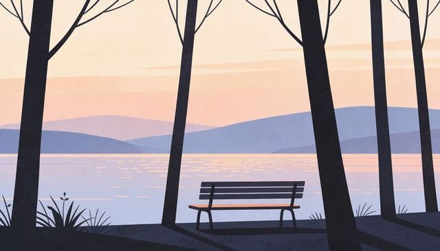 Solitary bench facing pastel lake at sunrise among bare trees casting long shadows