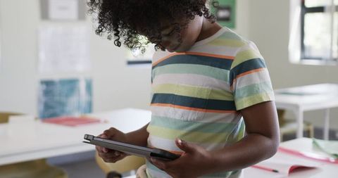African american boy using tablet in classroom learning with educational technology