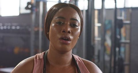 African american woman breathing heavily after intense workout closeup in fitness gym