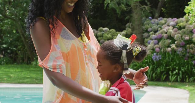 Happy african american mother and daughter embracing at pool. family, togetherness, relax and vacations concept.