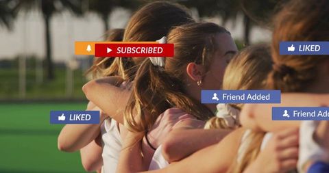 Sunlit female sports team hugging celebrating with social media notification overlays