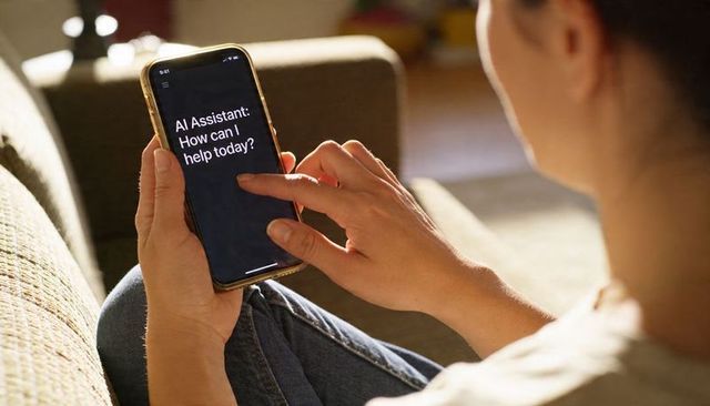 Woman tapping smartphone showing AI assistant while relaxing on sofa