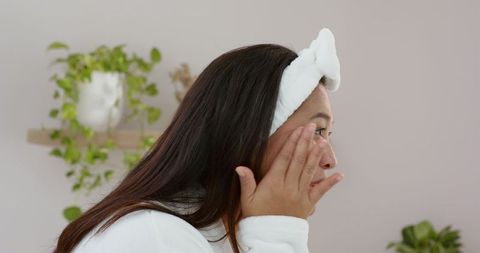 Woman Applying Eye Cream in Wellness Urban Bathroom Scene
