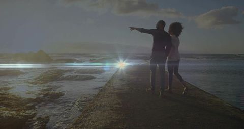 Couple on Oceanside Pier Enjoying Sunset Tranquility