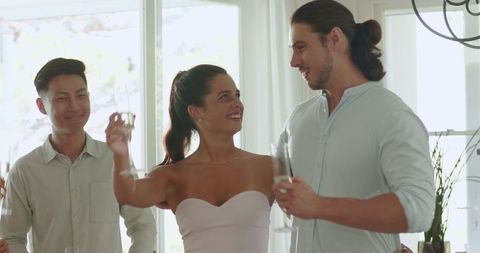 Friends Cheering at Home Celebration with Drinks