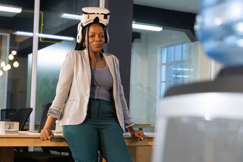 African american professional testing vr headset leaning on meeting table in modern office