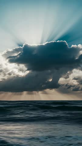 Sun Rays Casting Through Dark Clouds Lighting Ocean Waves Vertical Seascape Video