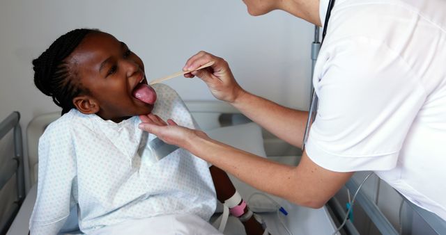 Pediatric Doctor Examining Young Patient's Throat in Hospital Bed - Download Free Stock Images Pikwizard.com