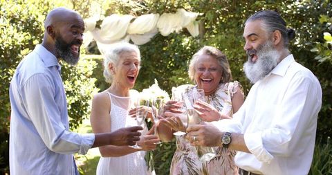 Senior friends celebrating outdoor wedding with champagne toast