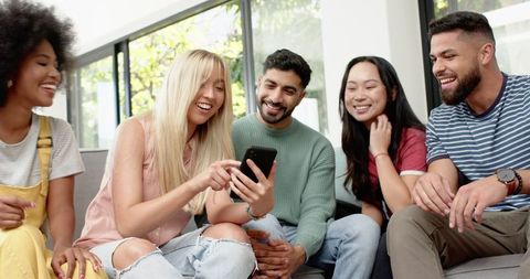 Multiracial Friends Laughing Together in Modern Living Room
