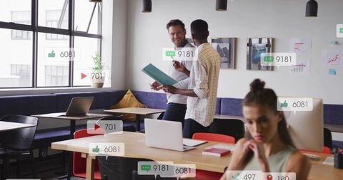 Diverse team collaborating in modern coworking office with social media engagement icons