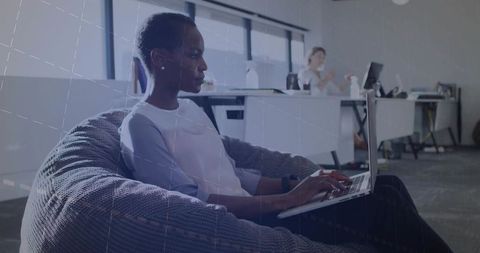 Focused professional typing on laptop in modern workplace