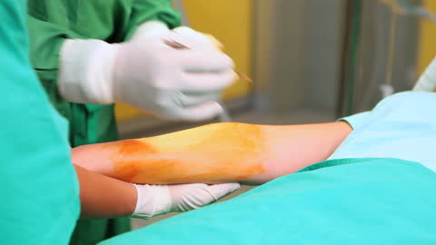 Surgeons Preparing Patient's Arm in Operating Room