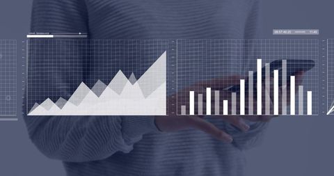 Holding tablet with holographic data dashboards showing line and bar charts for analytics